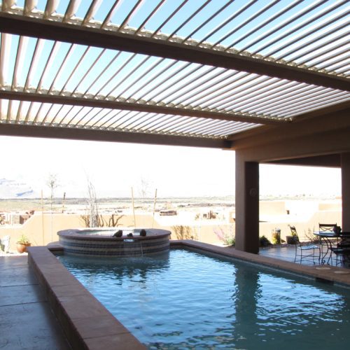 A residential backyard with a pool and a louvered patio cover by Equinox