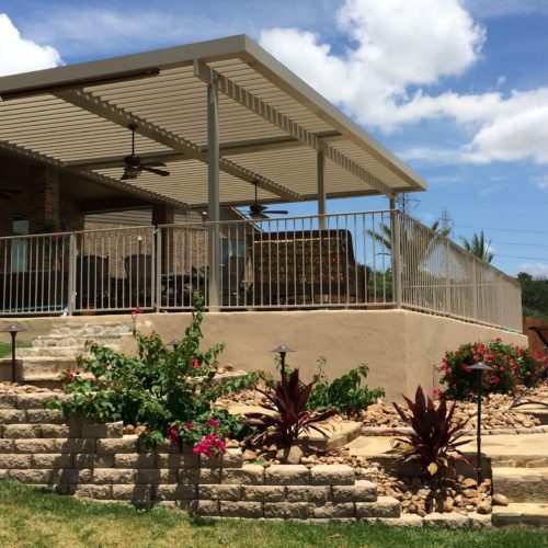 a residential backyard with a patio covering 