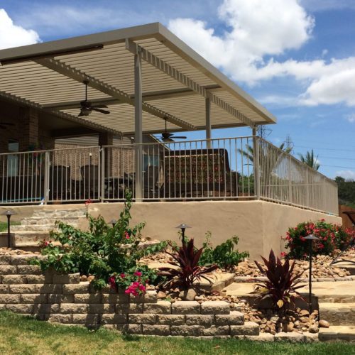 a residential backyard with a patio covering 