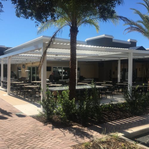 A restaurant outdoor patio shaded by a white pergola