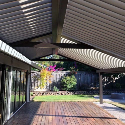 Louvered roof system shading residential backyard