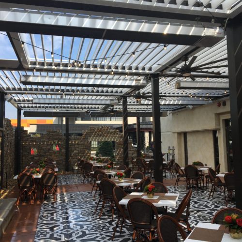 Outdoor dining area at Carmines Restaurant shaded by Equinox louvered roof 
