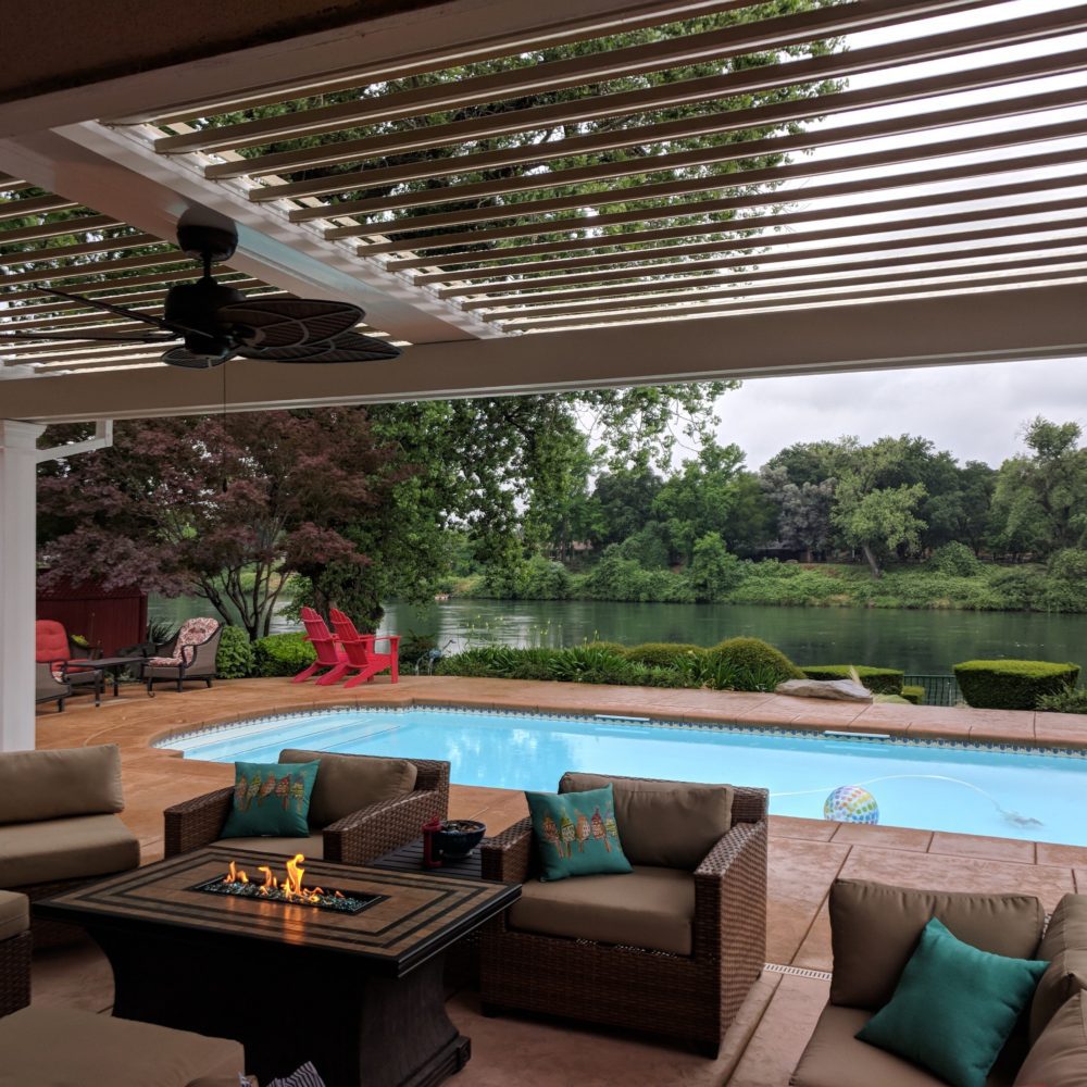 Open louvered roof over a residential backyard patio