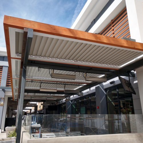 A faux wood pergola covers the dining area of a commercial buildings restaurant
