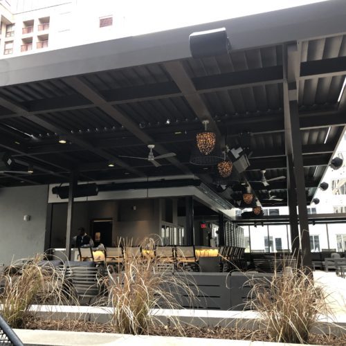A black patio cover over the outdoor dining area of a restaurant. 