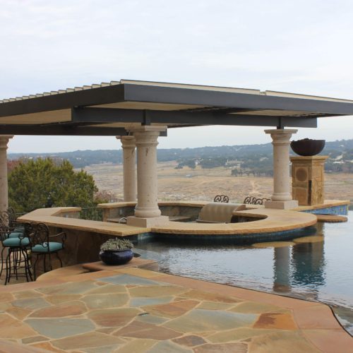 Custom pergola with louvered roof and 4 columns in a residential backyard with a pool.