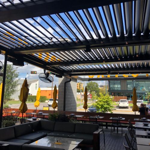Black open louvered patio covering in a commerical dining area