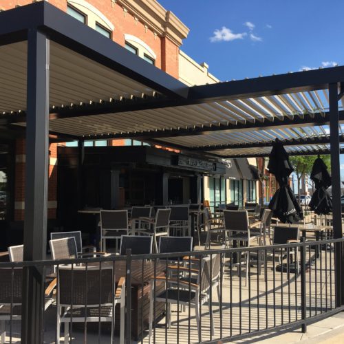 Alternative view of the motorized louvered patio cover over a restaurants outdoor dining area.