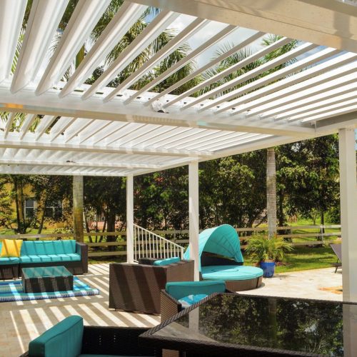 Outdoor patio covering with motorized louvers open to sunny skies in residential backyard