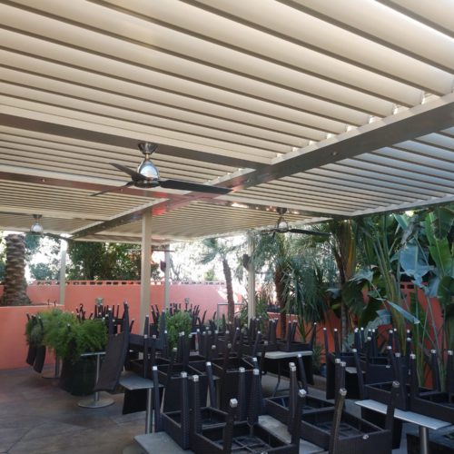 Alternative view of an outdoor seating area shaded by an equinox louvered roof and patio covering system 