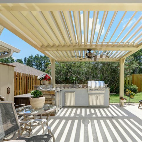 Open louvers on a patio covering an outdoor kitchen