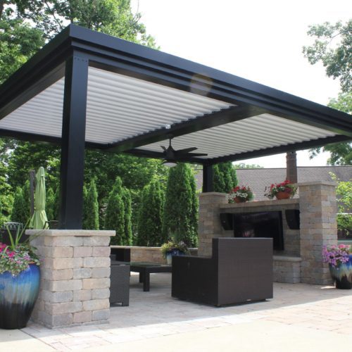 a black and white patio covering with open louvers in a residential backyard